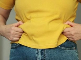 Cropped shot of a upset woman has overweight. she shows excess fat of the waist. she wants lose